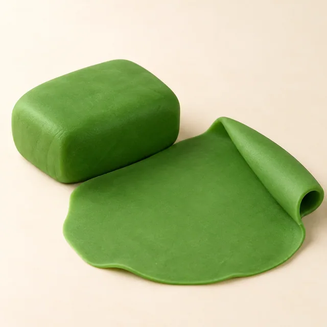 Eigene Illustration: Grüner Fondantblock und kleine daraus geformte Blätter und Stiele